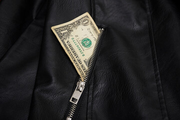 Dollar bill in leather jacket pocket