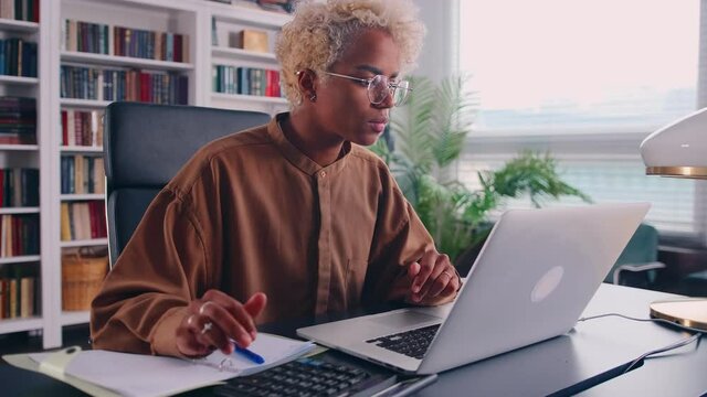 Busy dark skinned woman professional accountant preparing annual financial report checking result on calculator. Bicultural female freelancer counting tax rates declaring income. Bookkeeping.