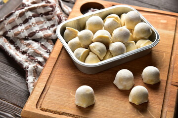 Frozen homemade raw food of ravioli on wooden board table
