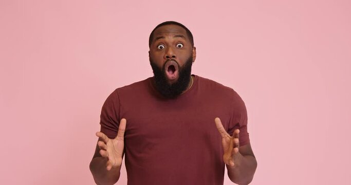 Young African american man surprised isolated on pink background