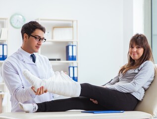Doctor examining patient with broken leg