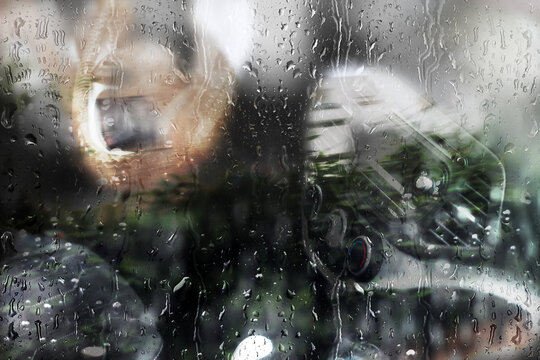 Rain, raindrops flow down the side glass window of the car. Rain drops on the glass. The main idea of the image - rainy weather, heavy rain