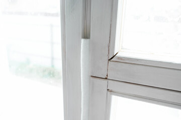 Insulated old window frames to prevent warmth heat leak and drafts, preparing house for winter and cold weather
