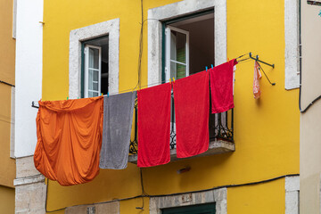 Traditional clothesline with clothes drying on windows in old property facades