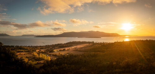 Panoramic Aerial Sunset View of Orcas Island. The sun is setting behind Orcas island with streaking...