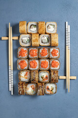 Traditional Japanese food - sushi, rolls and sauce on a dark background. Top view. Blue background