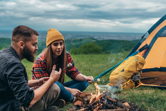 Couple Of Campers Eating Marshmallows While Camping In The Nature