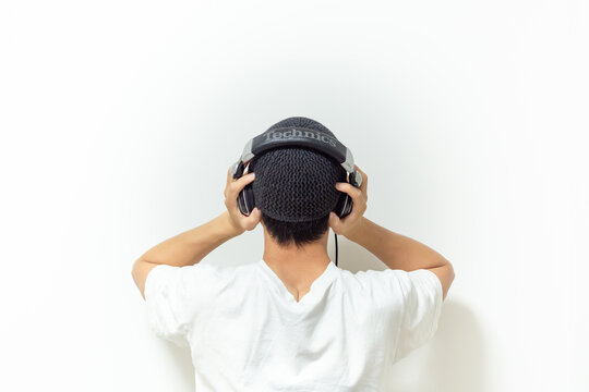 a man listening music with headphone and holding his head in front white background