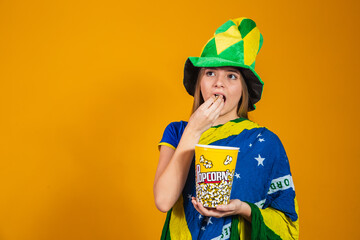 brazilian fan with popcorn to watch the game. entertainment and sport concept