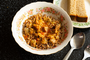 Boiled buckwheat porridge with goulash, pork meat pieces stewed in thick sauce with onions and...