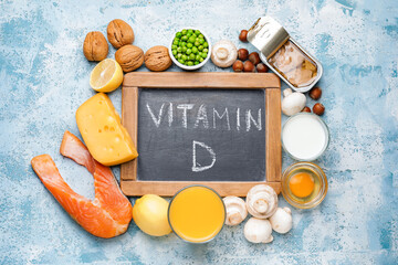Chalkboard with text VITAMIN D and different healthy products on color background