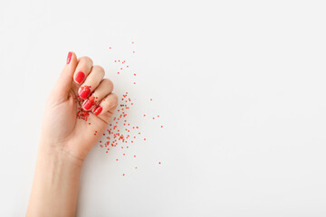 Female hand with beautiful manicure and glitters on white background