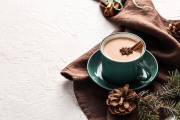 Composition with cup of hot cocoa drink and pine cones on light background
