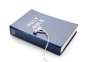 Holy Bible and earphones on white background