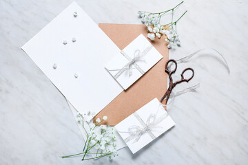 Cards with envelopes, flowers and scissors on white background