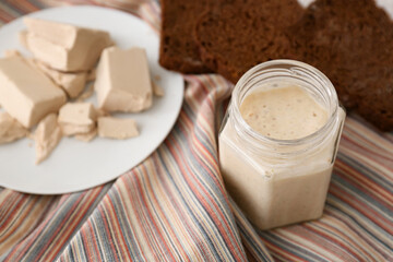 Glass jar with sourdough on table