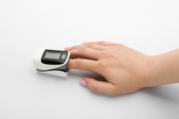 Woman with pulse oximeter on white background