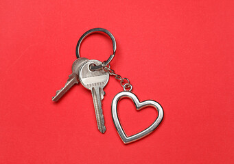 Keys with heart shape keychain on color background