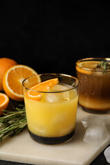 Glasses of tasty coffee with orange juice on dark background