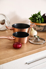 Cooking pots with onion on kitchen counter