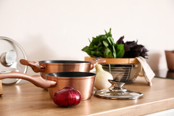 Cooking pot with onion on kitchen counter, closeup