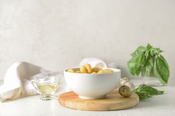 Bowl with tasty gnocchi on light background
