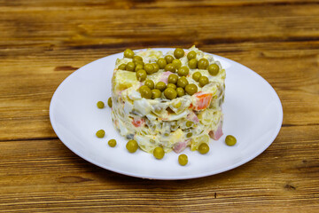 Traditional Russian festive salad Olivier on wooden table