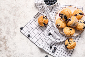 Composition with tasty blueberry muffins on light background
