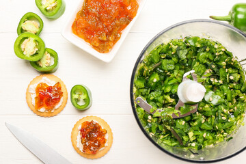 Blender and ingredients for delicious jalapeno pepper jam on white wooden table