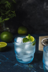 Glasses of cold gin tonic on dark background