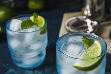 Glasses of cold gin tonic on dark background