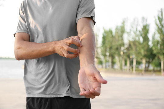 Young man scratching himself outdoors