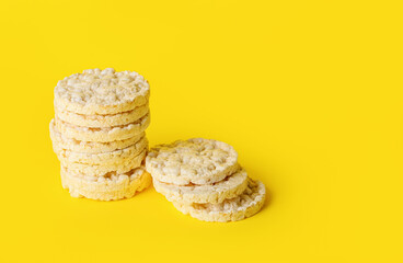 Stack of puffed rice crackers on yellow background
