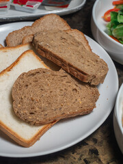 Sice of white and whole grain breads in the white plate.