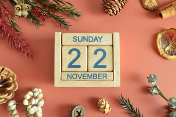 November 22, Cover design with calendar cube, pine cones and dried fruit in the natural concept.