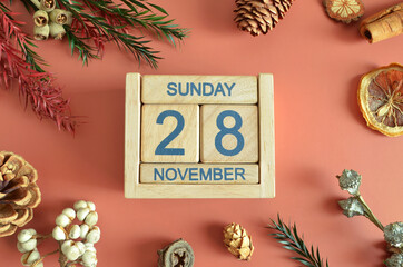 November 28, Cover design with calendar cube, pine cones and dried fruit in the natural concept.