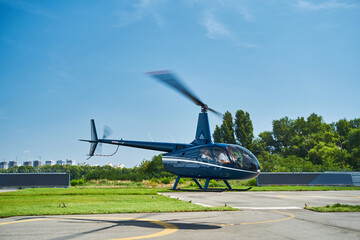 Manned private rotary-wing aircraft descending at heliport © Svitlana
