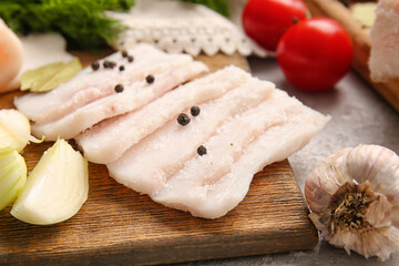 Wooden board with slices of salted lard on table, closeup