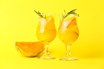 Glasses of tasty melon cocktail on yellow background