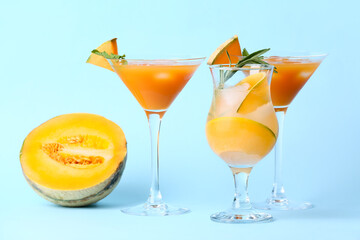 Glasses of cold melon cocktail on blue background