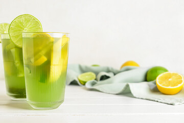 Glasses with tasty lemonade on light wooden background