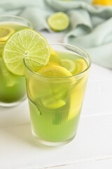 Glasses with tasty lemonade on light wooden background