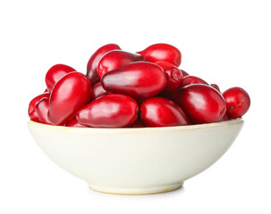 Bowl with ripe dogwood berries on white background