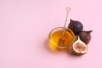Bowl with honey and ripe figs on color background
