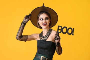 Beautiful young woman in Halloween costume of witch on color background