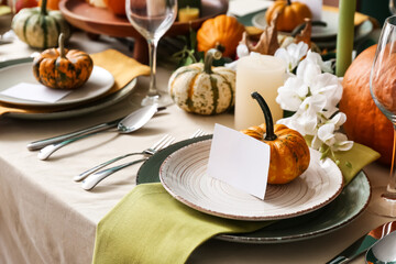Autumn table setting with fresh pumpkins in room