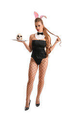 Young woman dressed as sexy waitress with skull on white background