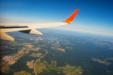 Fototapeta premium Classic image through aircraft window onto wing. Flight view over Russia