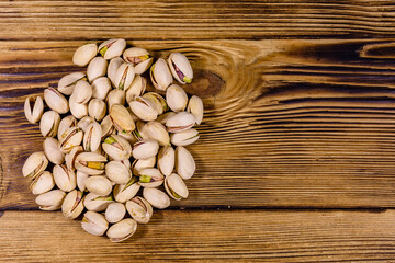 Pile of pistachio nuts on a wooden table