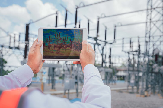 An electrical engineer uses a thermal meter to scan the structure and equipment of the power supply station to detect hot spots that can damage the system. Preventive maintenance